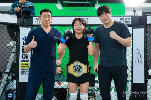 서울 광진경찰서 중곡4파출소에서 근무 중인 허유라(가운데)가 초대 KMMA 여성부 스트로급 챔피언 등극 후 메인스폰서 뽀빠이연합의원 김성배 대표원장(왼쪽) 및 김대환 KMMA 대표와 기념 촬영을 하고 있다. 사진=스탠다드앤드프로그레스 스포츠에이전시 제공