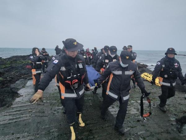 2일 소방대원들이 해녀와 수색팀이 공동으로 찾아낸 실종자 인도네시아 선원의 시신을 인양해 이송하고 있다. 제주도소방안전본부 제공