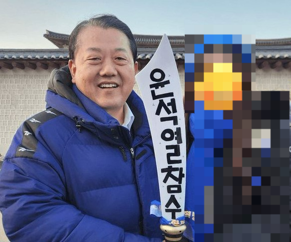 김병주 더불어민주당 최고위원이 지난 22일 서울 종로구 안국역 일대에서 열린 ‘윤석열 파면 촉구 범국민대회’에 참석했다가 한 참석자와 ‘윤석열 참수’라고 쓰인 모형칼을 들고 사진을 찍은 모습(사진 일부 모자이크 처리함). 박민영 국민의힘 대변인 페이스북 캡처