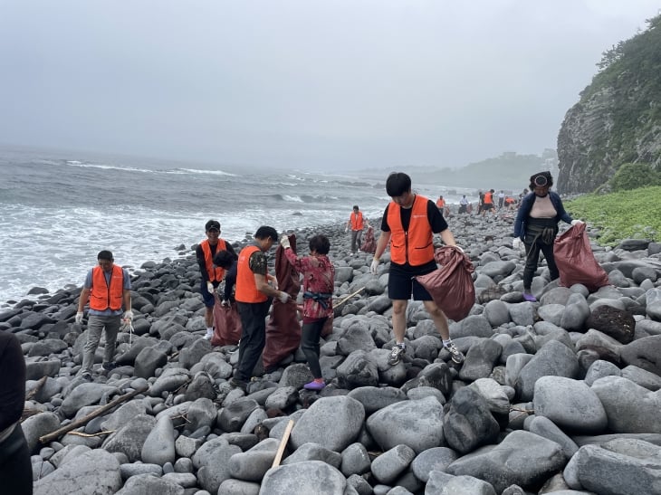 퍼시픽리솜 임직원과 색달어촌계 해녀들이 5일 제주 중문 색달해수욕장에서 환경 정화활동을 하고 있다. 사진: 호반호텔앤리조트 제공.