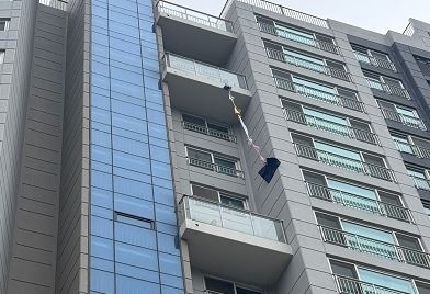 서울 종로구의 한 아파트 고층에 옷으로 엮은 줄이 걸려 있다. 연합뉴스