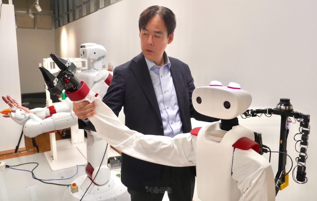 지난 11일 일본 도쿄 신주쿠구 와세다연구개발센터에서 오가타 데쓰야 와세다대 교수가 세미 휴머노이드 ‘아이렉 베이직’을 소개하고 있다. 수건 개기 등 간단한 집안일을 돕도록 설계된 이 소형 로봇은 대형 휴머노이드의 위압감을 줄여 생활 공간에서도 거부감 없이 받아들여질 수 있도록 제작됐다.
